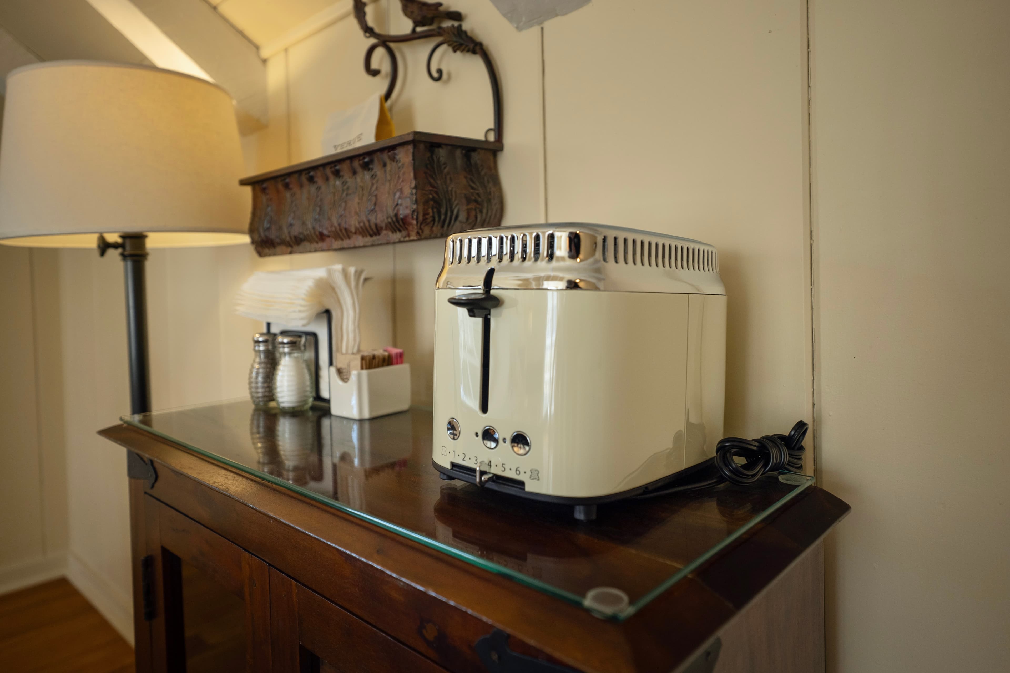 Close up view of a retro toaster, side table and lamp.